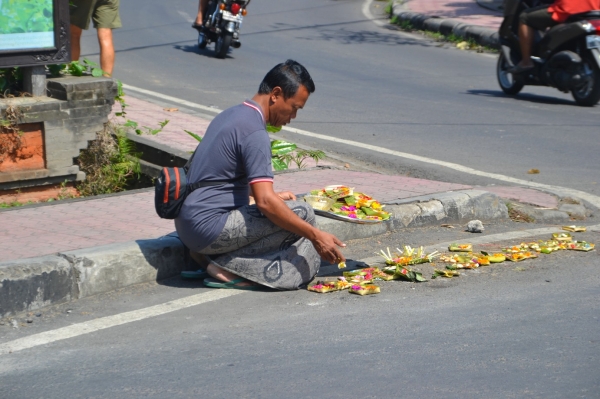 Zdjęcie z Indonezji - Pan rozkladajacy koszyczki ofiarne