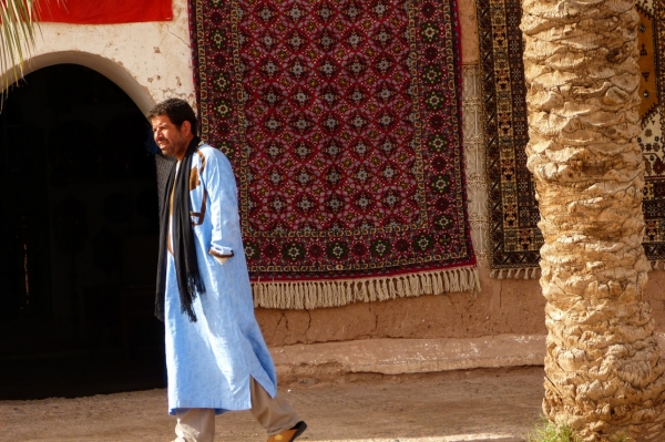 Zdjęcie z Maroka - marokańczyk w gandorze na tle dywanu...  bardzo fajny widok:)