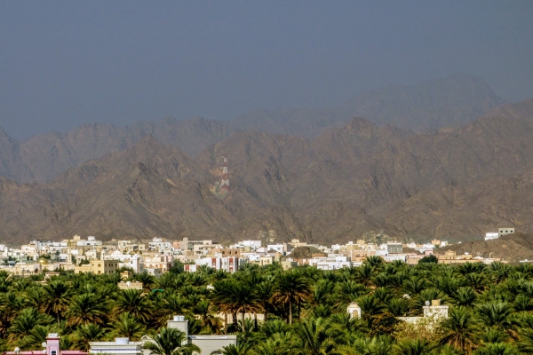 Zdjęcie z Omanu - soczyscie zielona oaza, białe domki i góry w tle - oto NIZWA właśnie!