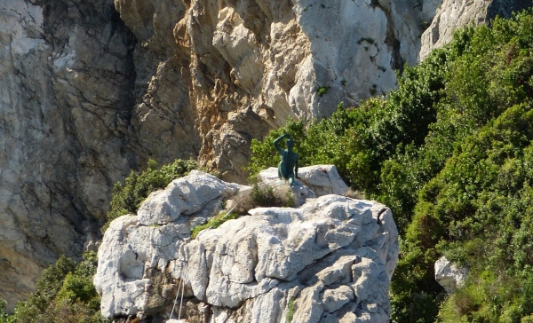 Zdjęcie z Włoch - "chłopiec z Capri" - siedzący na skale pozdrawia przybyszów