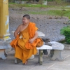 Zdjęcie z Tajlandii - Buddyjski mnich lypie okiem do obiektywu u stop