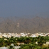 Zdjęcie z Omanu - soczyscie zielona oaza, białe domki i góry w tle - oto NIZWA właśnie!