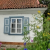 Zdjęcie z Polski - Wzrok przyciągają urocze okienka z okiennicami i barwne kwiaty na tle białych ścian.