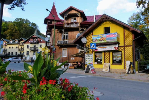 Zdjęcie z Polski -  Drewniany budynek z zewnętrznymi zadaszonymi balustradami balkonowymi i charakterystyczną niewielką