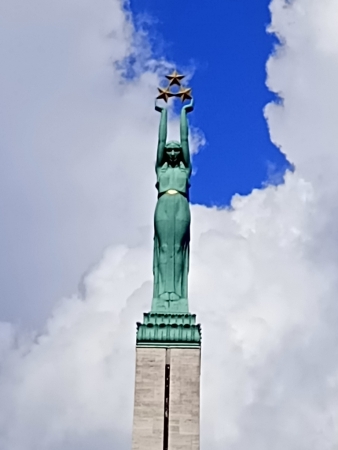 Zdjęcie z Łotwy - ta samotna kobieta na szczycie trzyma trzy złote gwiazdy, które