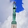 Zdjęcie z Łotwy - ta samotna kobieta na szczycie trzyma trzy złote gwiazdy, które